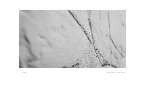 Pale abstract surfaces crossed by dark diagonal streaks, framed by a white print border.